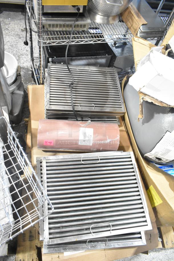Pallet lot with exit signs, metal baskets, grease filters, butcher paper roll, Fisher faucet handles, and coupler.