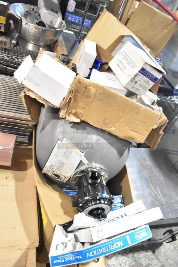 Pallet with various items, including exit signs, metal baskets, grease filters, butcher paper, Fisher faucet handles, coupler, and tank.