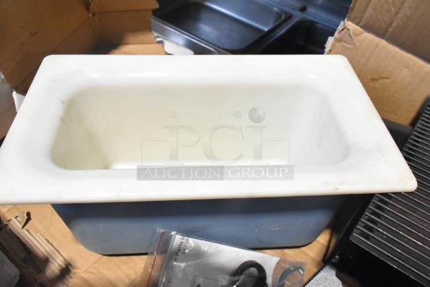 Pallet lot with various items including exit signs, metal baskets, grease filters, butcher paper roll, faucet handles, and other components.