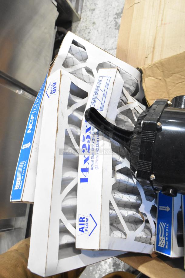 Pallet with air filters, marked "14x25x1," and a black device. Filters in original packaging, showing airflow direction.