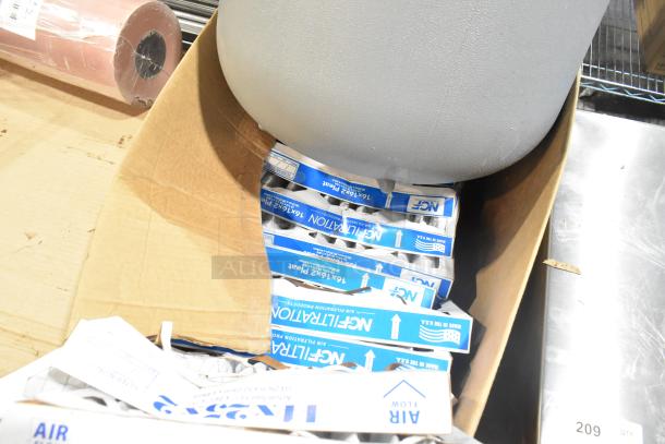 Pallet with various items including rolls of peach butcher paper, metal fixtures, and air filters. Some items in original packaging.