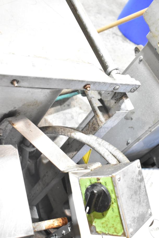 Stainless steel commercial braising pan with control knob. Visible wear and oxidation. Ideal for large-scale cooking.