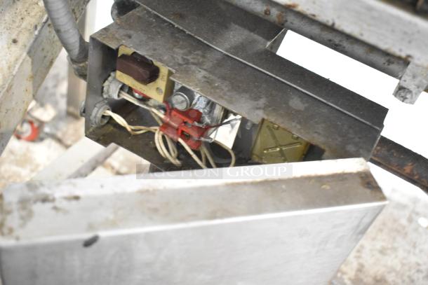 Stainless steel commercial braising pan with visible wiring and controls. Shows wear and rust, indicating used condition.