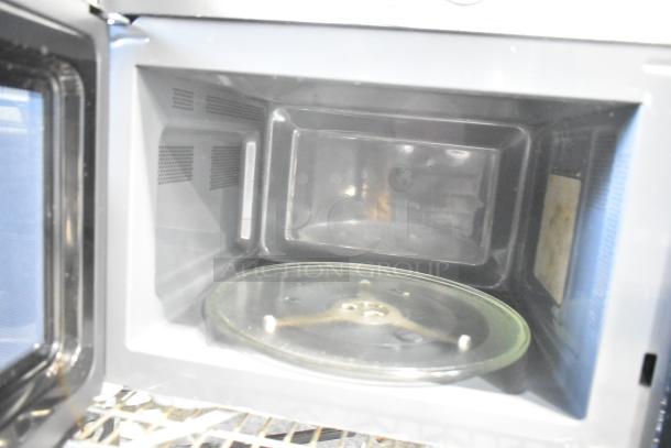 Magic Chef MC110MST metal countertop microwave oven interior with glass turntable. 120V, 1 phase. Slightly used condition.