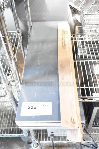 Box of ceramic wall tile, glossy gray finish, new condition, with a label marked "222 QTY," stored on metal shelving.