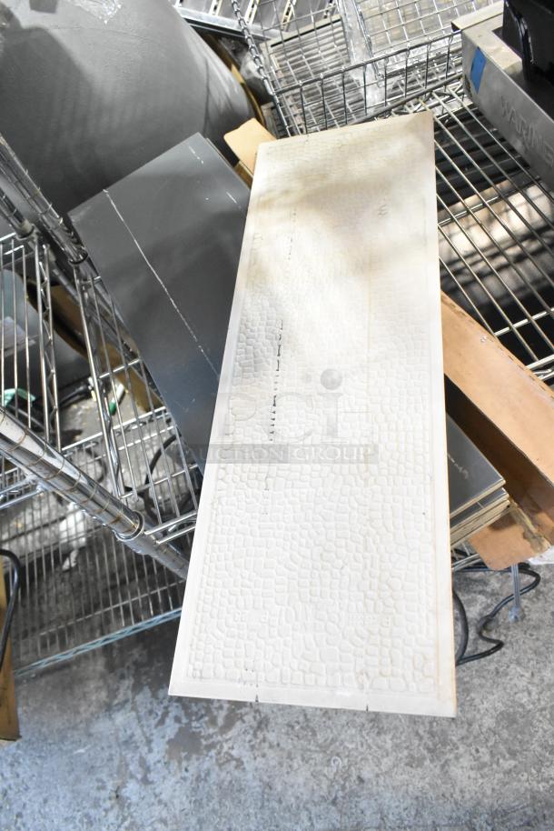 Box of ceramic wall tile with textured white pattern, new condition, stacked on metal shelving.