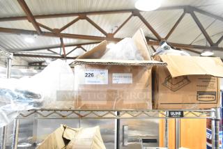 Cardboard boxes with various items including Rubbermaid amber drop-in bins, cables, and brackets, labeled for auction.