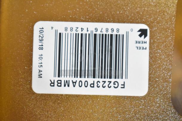 Amber Rubbermaid drop-in bin with barcode label "F6223P00AMBR" and date "10/29/18" in tier lot of various items.