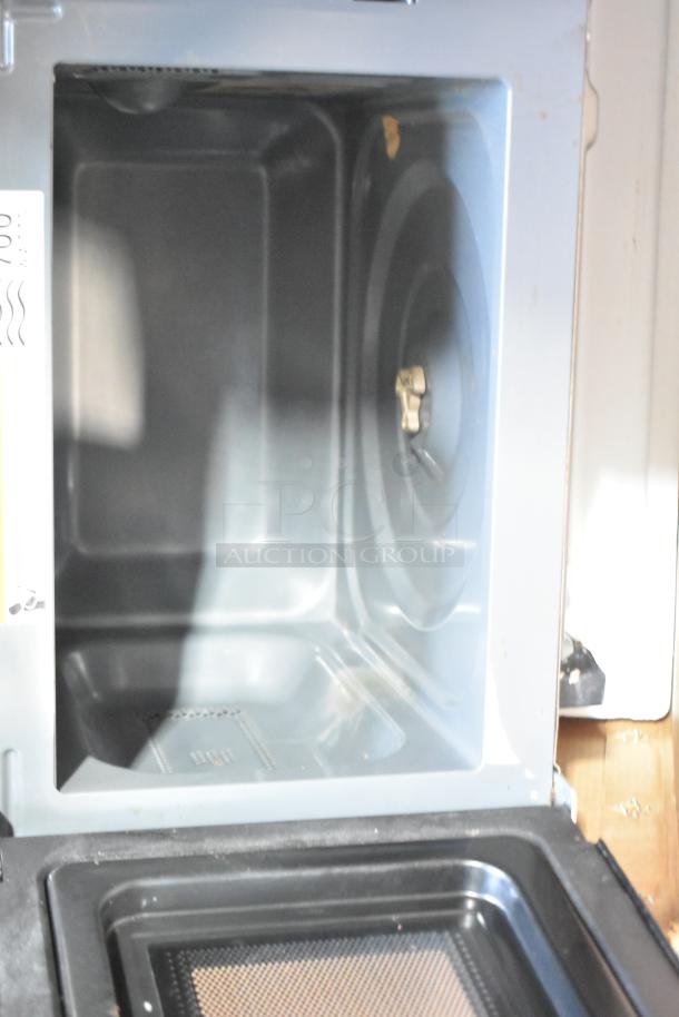 Black & Decker EM9225AB9 countertop microwave oven in original box. Appears in lightly used condition. Includes plate.