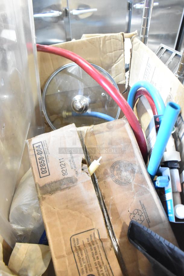 Auction lot with miscellaneous items including poly bins, Kay hand sanitizer, and a glass lid. Various hoses included.