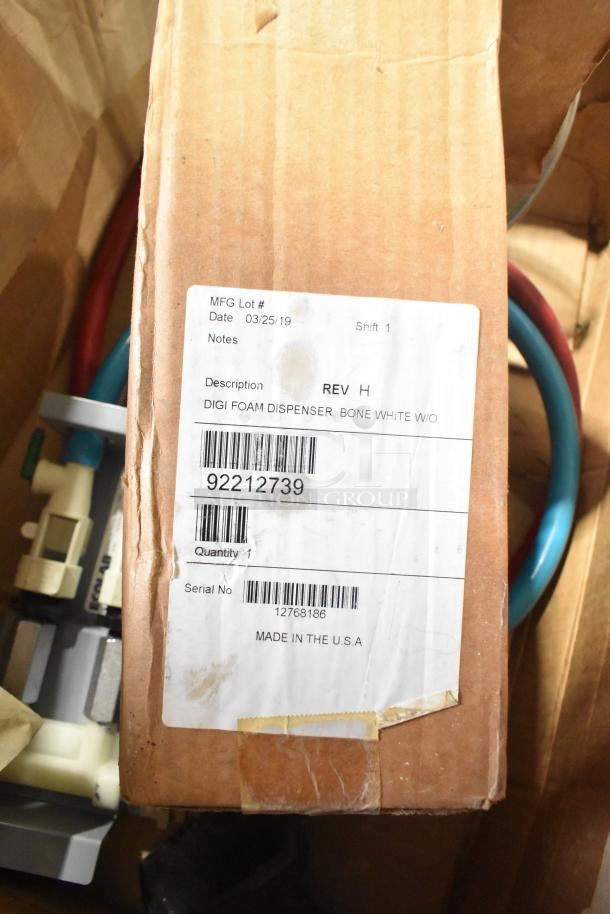 Cardboard box with a label detailing a Digi foam dispenser, bone white, Rev H. Includes a barcode and "Made in the USA".