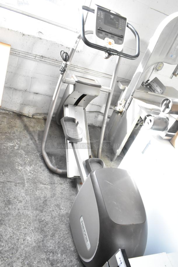 Precor floor style elliptical, 120 volts, 1 phase, in used condition. Features visible control panel and sturdy frame.