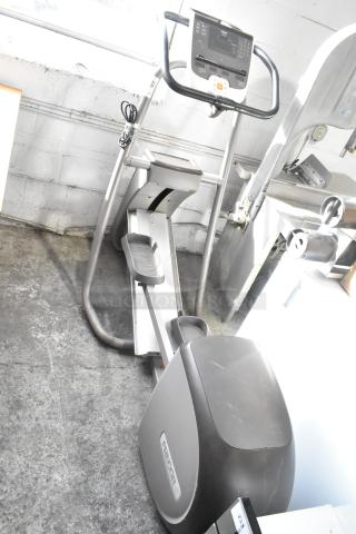 Precor floor style elliptical, 120 volts, 1 phase, in used condition. Features visible control panel and sturdy frame.