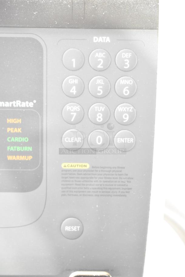 Precor elliptical control panel showing numeric keypad, SmartRate zones, and caution label. Features 120 volts, 1 phase.