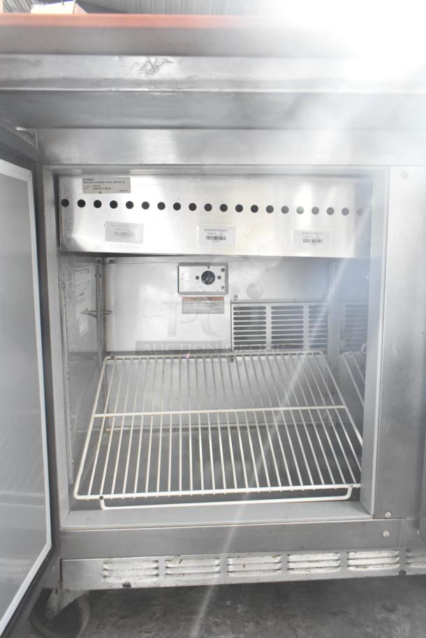 Beverage Air SPE48-18M stainless steel sandwich prep table, interior view with wire shelf, commercial casters visible.