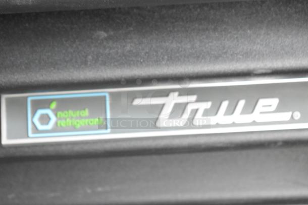 Close-up of True logo and natural refrigerant label on the 2024 True TVM-48SL-HC 2 Door Reach In Cooler.