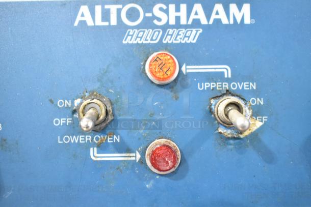 Alto Shaam 1000-TH control panel with switches for upper and lower oven, indicator lights, and brand markings visible.