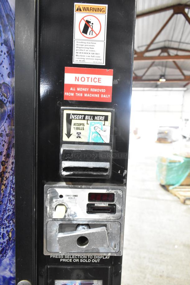 Metal commercial bottle vending machine, accepts $1 bills, 115 volts, 1 phase, warning and notice labels visible.