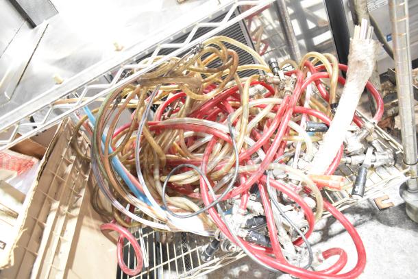 Tiered lot of assorted kegerator hoses and couplers. Used condition. Includes various colored hoses and metal couplers.