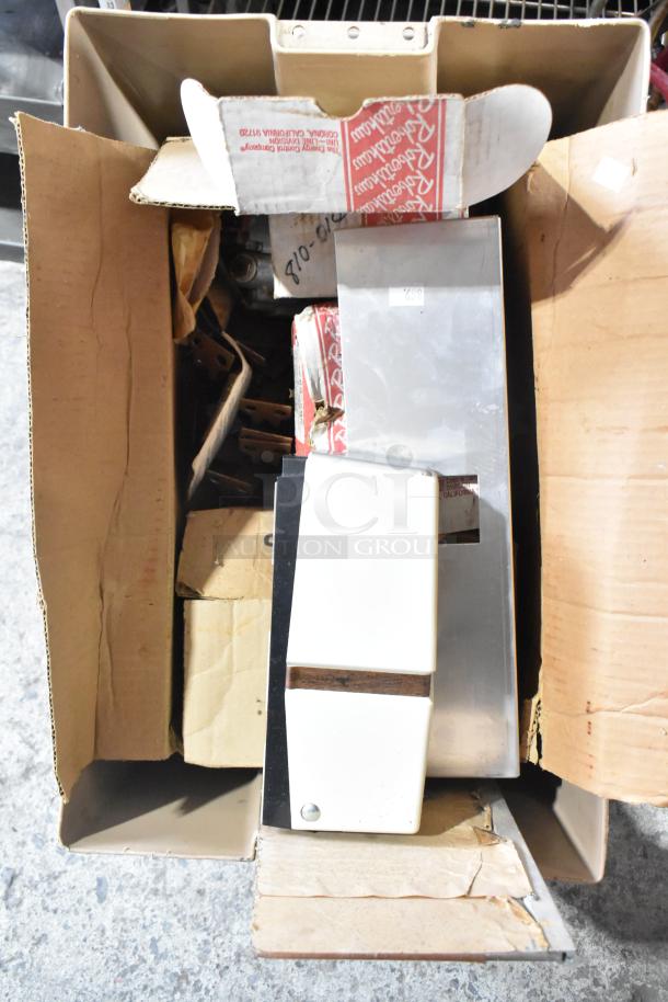 A cardboard box containing various items, including kegerator hoses and couplers. Items include metal parts and packaged components. Condition appears used.