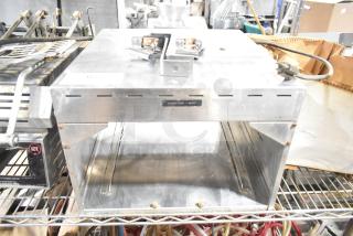 Metal commercial countertop warmer, 115 volts, 1 phase, silver with "Caution: Hot" label, moderate wear.