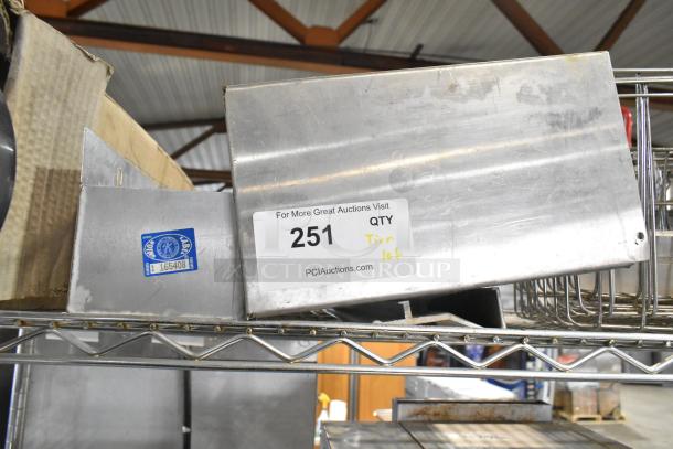 Assorted items including a cup dispenser, fry basket, and metal pieces on a shelf. Label marked "251 Tier lot."