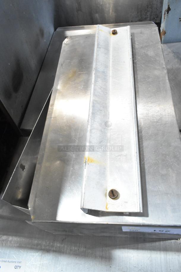 Auction lot including cup dispenser, fry basket, and metal pieces. Items show visible wear. Includes tag marked "LOT 67."