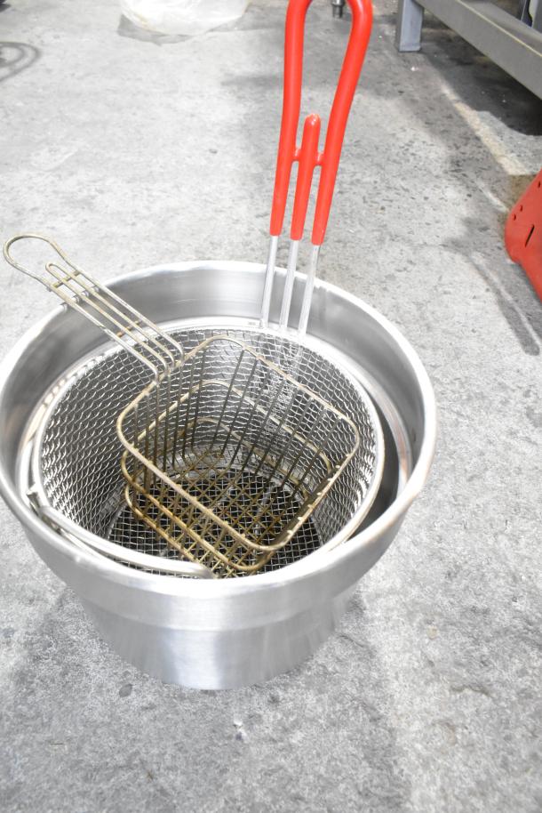 Various kitchen items including metal fry basket with red handles and stainless steel cup dispenser in used condition.