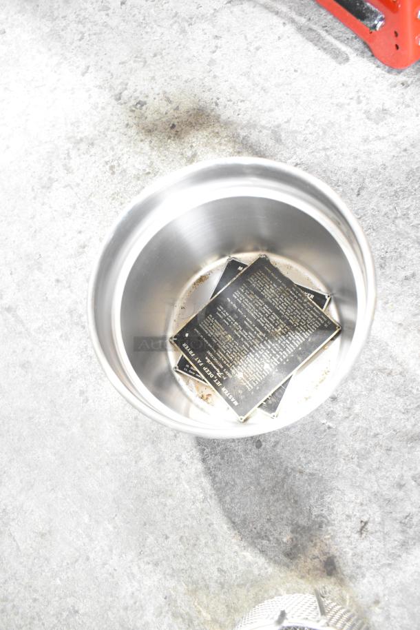 Lot of various items including a stainless steel container with metal plaques, showing wear. Includes cup dispenser and fry basket.