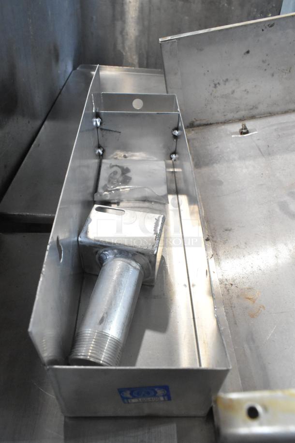 Metal box containing various items including a cup dispenser and metal pieces, showing industrial use and construction.