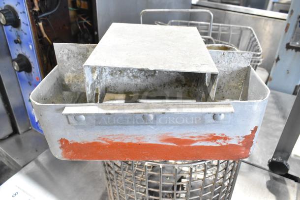 Auction lot includes a metal fry basket, cup dispenser, and assorted metal pieces. Visible wear and rust.