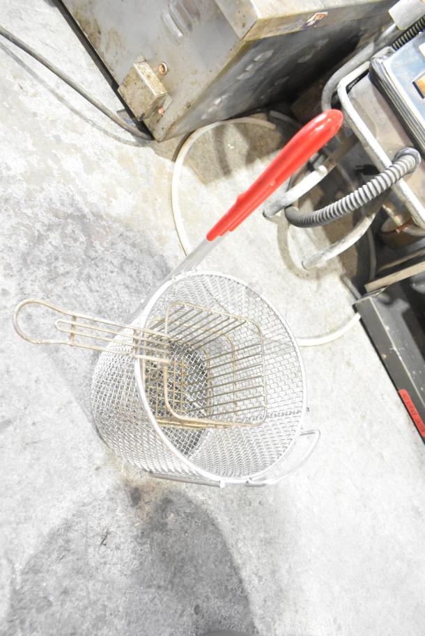 Tier lot including a metal fry basket with red handle, cup dispenser, and assorted metal pieces. Used condition.