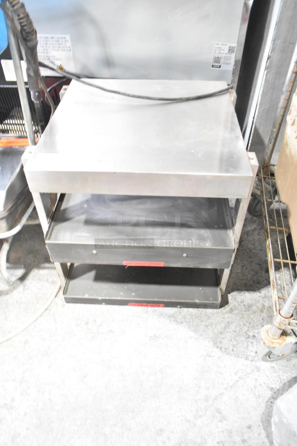 Stainless steel commercial countertop two-tier warmer, 115 volts, 1 phase, with visible tags indicating "Hot Surface Caution."