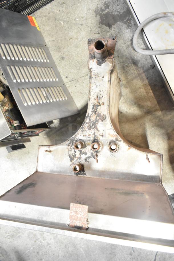 Stainless steel unit with rust and wear, featuring multiple attachment points. Suitable for industrial use.