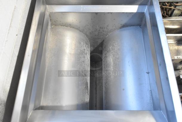 Metal commercial fryer frame, silver finish, showing some wear and oxidation, industrial-grade construction.