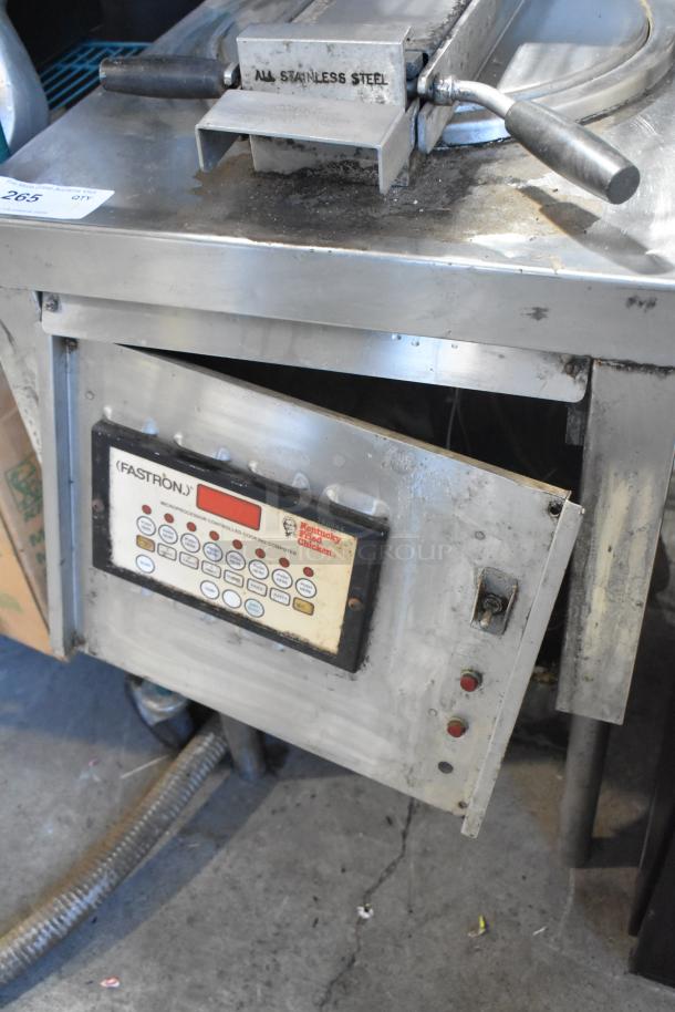 Stainless steel commercial pressure deep fat fryer with electronic control panel. Used condition, visible wear, model "FASTRON."