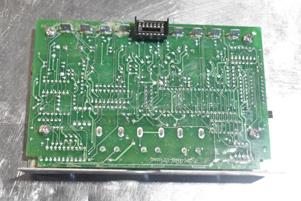 Green circuit board with visible solder points and connector, part of a lot including ice cream machine auger and other components.