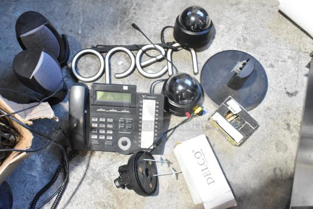 Lot of various items including a Vertical telephone, "Open" sign, cameras, speakers, Delco box, and cables. Mixed condition.
