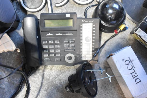 Lot includes Vertical SBX telephone, black dome camera, open sign, speaker, and Delco box. Items appear mixed condition.