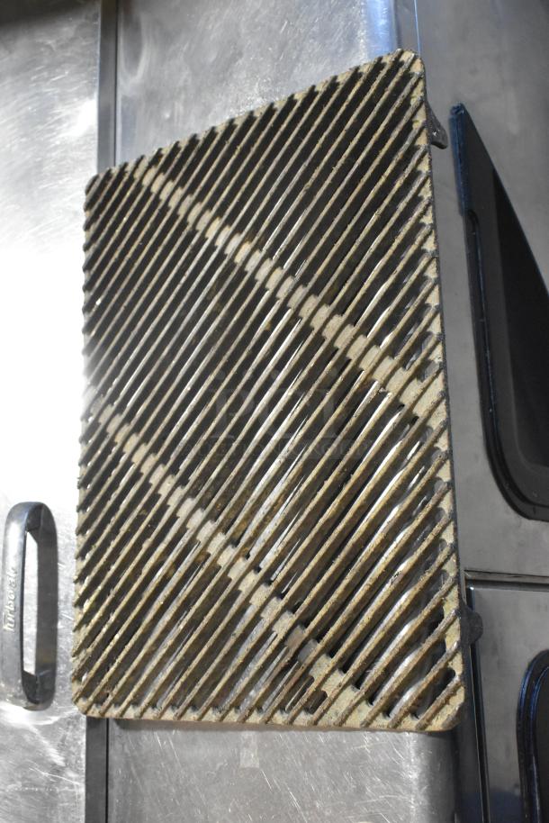 Metal grate with diagonal slats, showing signs of wear. Part of a set of 8, enhancing value with multiple uses.