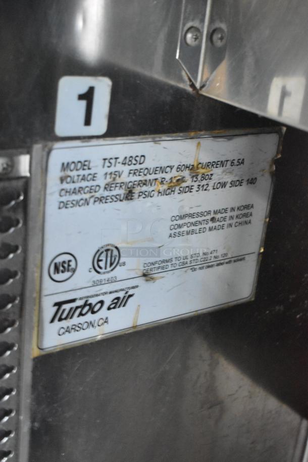 Turbo Air TST-48SD stainless steel sandwich salad prep table, 115V, 1 phase, commercial casters, label shows model and specs.