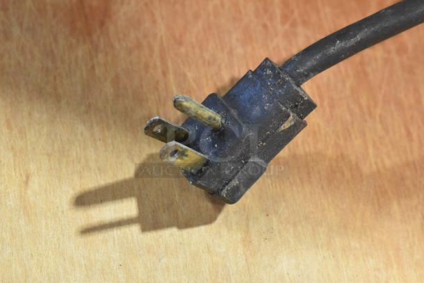 Close-up of a plug from the Randell 8268N stainless steel commercial pizza prep table, showing signs of wear.