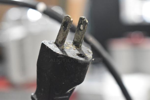 A close-up of a worn electrical plug, part of the Robot Coupe R2N Commercial Food Processor.