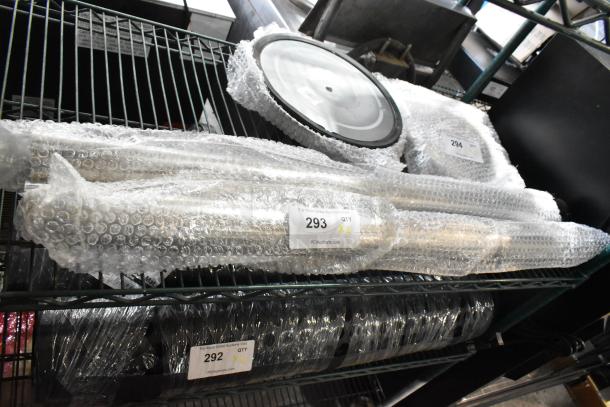 Brand new chrome finish stanchions, wrapped in bubble wrap, labeled as scratch and dent, quantity two, tags visible.