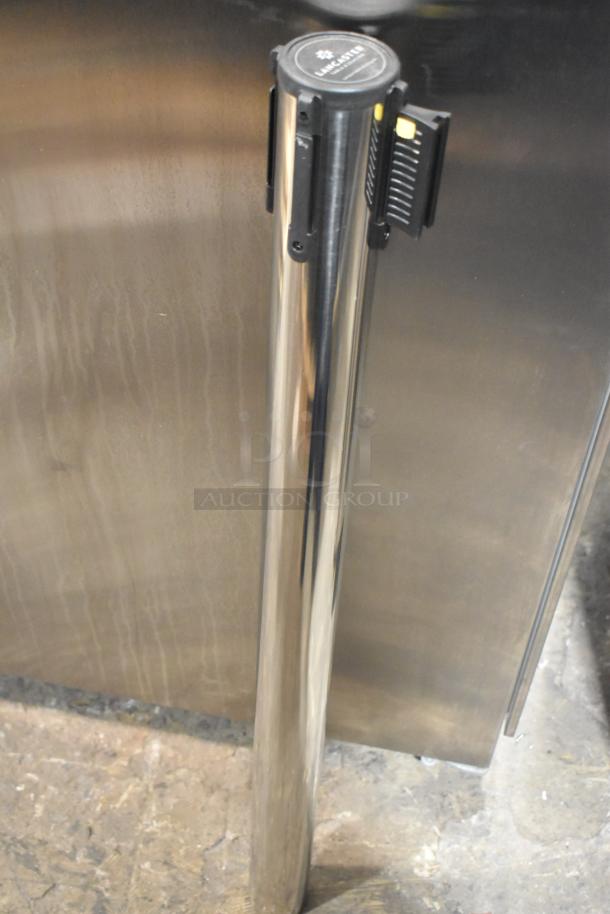 Chrome finish stanchion, brand new, minor scratch and dent, with retractable belt mechanism, top label visible.