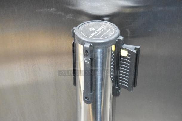 Brand new chrome stanchion with scratch and dent. Features Lancaster branding. Retractable belt design.
