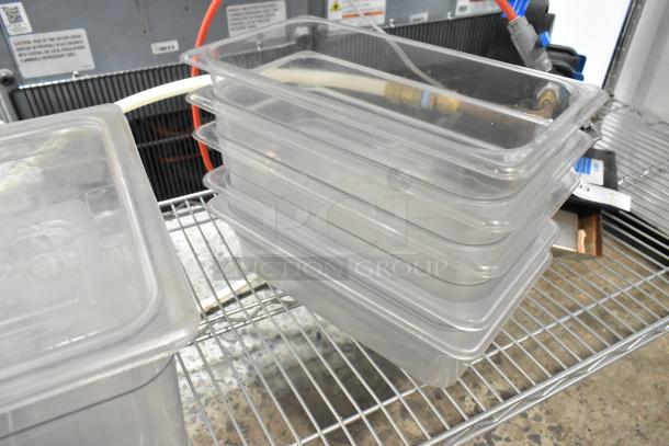 Lot of 6 clear poly bins, stacked on a metal shelf. Used condition, suitable for storage or organization.