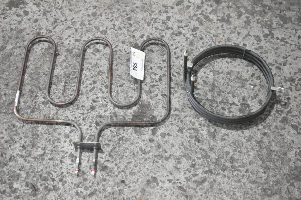 Two metal burners, one coil and one flat, with visible label marked "305." Items in used condition on concrete surface.