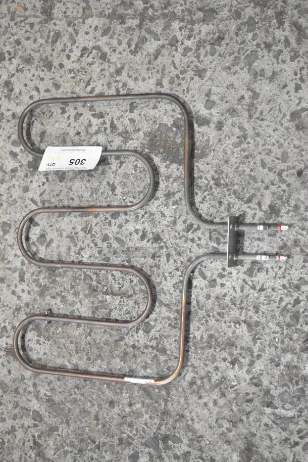 Two metal heating elements resting on a textured surface, featuring a bid tag reading "305" and signs of light use.