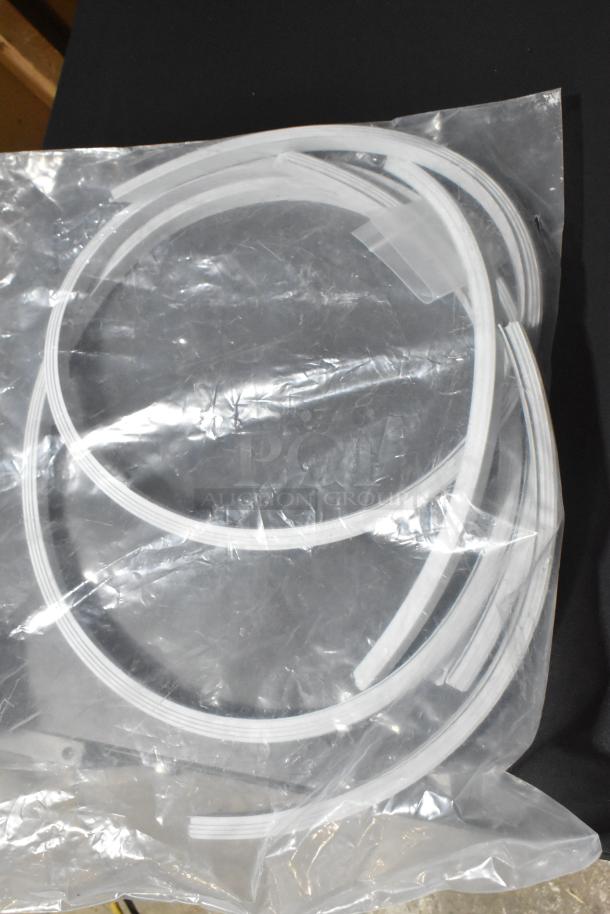 Coiled plastic seal in clear packaging, new condition, features ribbed edges for secure sealing.